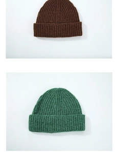Detail view of brown and green ribbed knit wool beanie hats with classic fold-over cuff