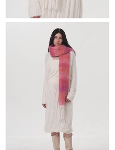 Dettaglio della sciarpa in lana mohair sfumata rosa e arancione con frange bianche