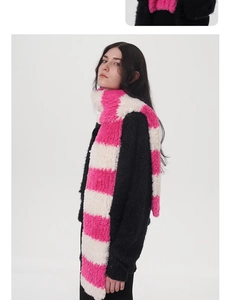 Details der dicken, weichen Plüschstruktur des rosa und beige gestreiften Winterschals