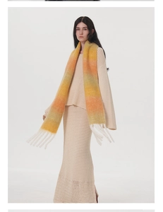 Dettaglio della sciarpa in mohair sfumato con frange che mostra la trama di lana colorata