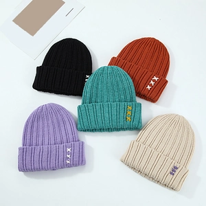 Bonnets en maille de plusieurs couleurs avec broderie XXX pour l'hiver posés à plat