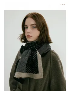 Détail de la texture en maille d'une écharpe d'hiver à pois avec bordure beige