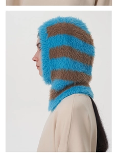 Detailansicht der weichen Webpelz-Struktur auf der blau-braun gestreiften Balaclava-Mütze