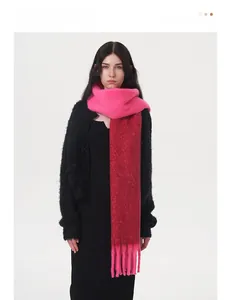 Detailed texture of thick two-tone pink and red knit scarf with long decorative tassels