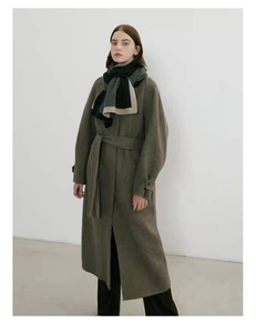 Vue détaillée de l'écharpe en maille jacquard à pois noirs et gris avec un manteau en laine