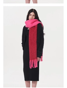 Detail of soft gradient pink mohair-style scarf featuring long tassel fringe and cozy texture
