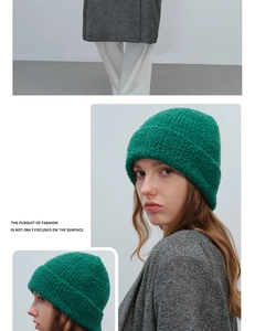 Detailed texture of green boucle knit beanie with fluffy wool yarn and folded cuff design