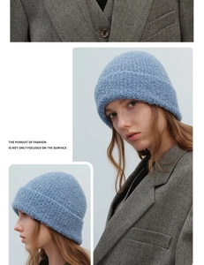 Detail of light blue bouclé knit beanie showing textured wool blend material on a model