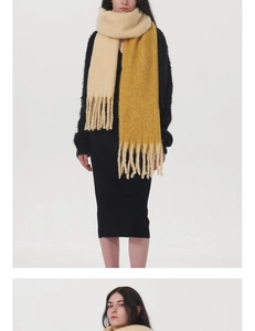 Close-up of thick bicolor faux cashmere scarf with cream and yellow knit and long fringes