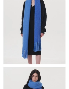 Close-up of royal blue knit scarf featuring long fringe tassels and soft cashmere texture