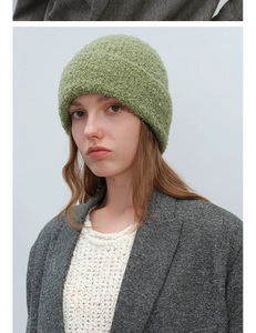 Close-up of green boucle wool knit beanie with premium textured finish on female model
