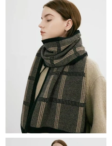 Detail of thick knit winter scarf featuring classic black and brown plaid patterns