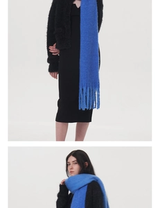 Detail view of royal blue knit scarf showing soft fluffy texture and long fringe tassels