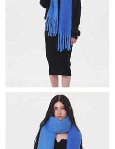 Detail of blue knit scarf with long tassels showing soft texture and fluffy mohair style