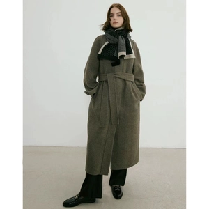 Écharpe en tricot à pois minimaliste portée avec long manteau en laine et mocassins