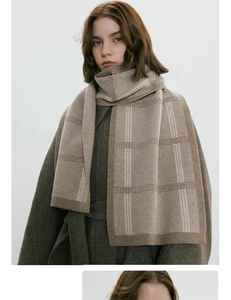 Detail of soft beige and light coffee plaid knitted scarf on a charcoal coat