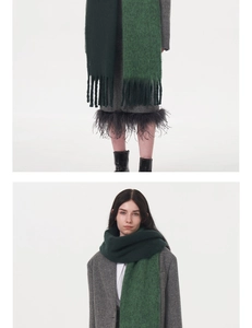 Detailed macro view of the two-tone dark and light green knit scarf with thick tassels