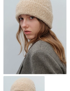 Close-up of beige bouclé knit beanie showing soft textured wool yarn and chunky cuff style