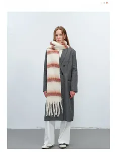 Detail view of the soft fringe and gradient red-brown striped scarf on a model