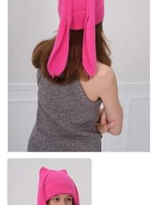 Close-up of bright pink knitted beanie with long rabbit ears and soft mohair texture