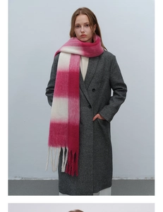 Nahaufnahme des flauschigen rosa-cremefarbenen Karoschals mit langen Fransen und Wolltextur