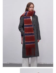 Close-up detail of soft red and navy blue striped scarf featuring long fringe tassels