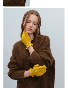 Close-up of yellow knit wool gloves with textured cuffs on a model's wrist