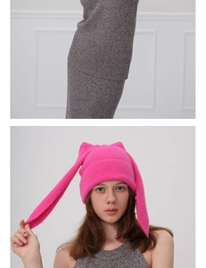Detail of bright pink knitted beanie with cat ears and long rabbit ear decorations