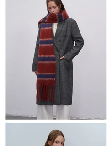 Macro view of rust red and navy blue striped knit scarf with long tassel details