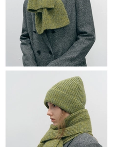 Texture détaillée en tricot d'un ensemble bonnet et écharpe en laine vert herbe d'hiver