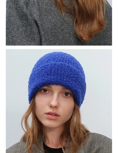 Close-up of a royal blue boucle knit beanie showing thick texture and warm winter material