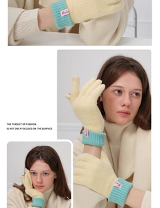 Detail of wool knit gloves featuring light blue ribbed cuffs and red brand label