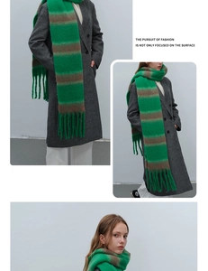 Detail of green and brown striped scarf showing thick knit texture and fringe accents