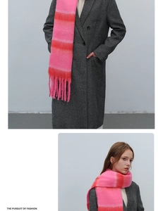 Detail shot of chunky striped knit scarf in bright pink and orange with long fringe edges