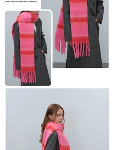 Detailed view of thick striped knit scarf with pink and orange gradients and fringe