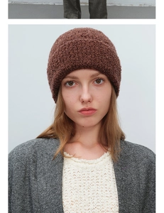 Close-up of brown textured boucle knit beanie showing the warm wool blend material