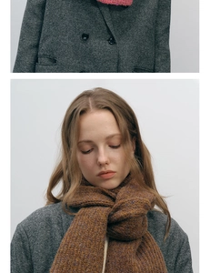 Détail d'écharpe en maille épaisse marron caramel sur un manteau en tweed gris chiné