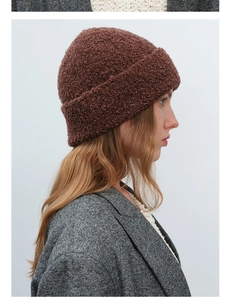 Detailed texture of thick brown fleece knit beanie showing warm boucle yarn material
