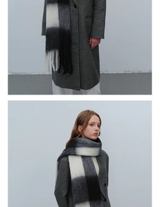 Nahaufnahme eines dicken Karo-Schals mit langen Fransen und weicher Mohair-Textur in Grau