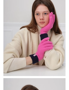Close-up of pink wool knit gloves with blue ribbed cuffs and touch screen fingertips
