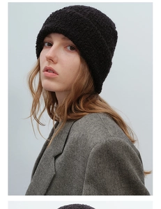 Detail of black bouclé knit beanie showing fuzzy texture and trendy cuffed style