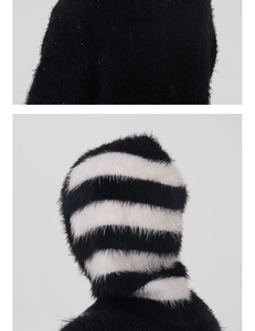 Detailed close-up of fluffy black faux mink fur and striped knit balaclava texture