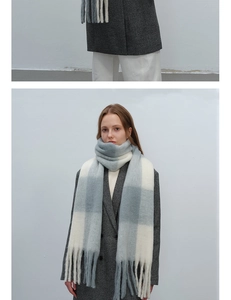 Detail eines blau-beigen karierten Plüschschals mit dicken Fransen und Mohair-Textur