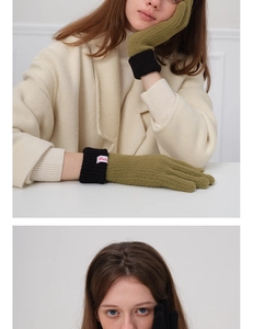 Close-up of olive green wool knit gloves with black ribbed cuffs and Mula label