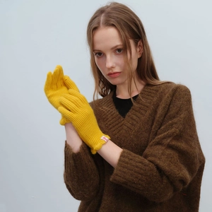 Bright yellow wool knit gloves with classic ribbed texture and brand tag for winter warmth
