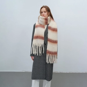 Thick striped mohair scarf with large tassels worn with a grey wool coat for winter