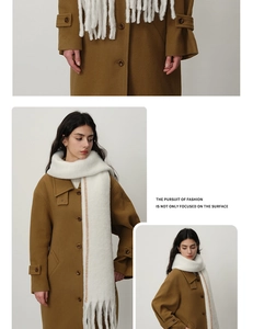 Detail of white plush scarf with contrast stitching paired with a camel wool coat