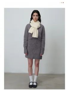 Détail de la texture d'une écharpe en maille beige portée sur une robe violette