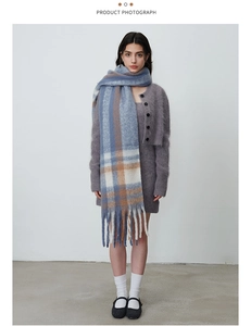 Detail of blue and brown checkered scarf featuring thick fringe and soft mohair texture