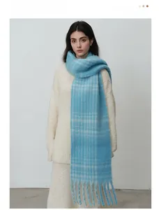 Detail showing the long tassel texture and blue checkered pattern of the winter scarf